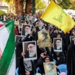 Protesters in Tehran wave Iranian flags, Hezbollah flags, and hold images of Supreme Leader Ayatollah Ali Khamenei during an anti-Israel rally on October 24, 2024.
