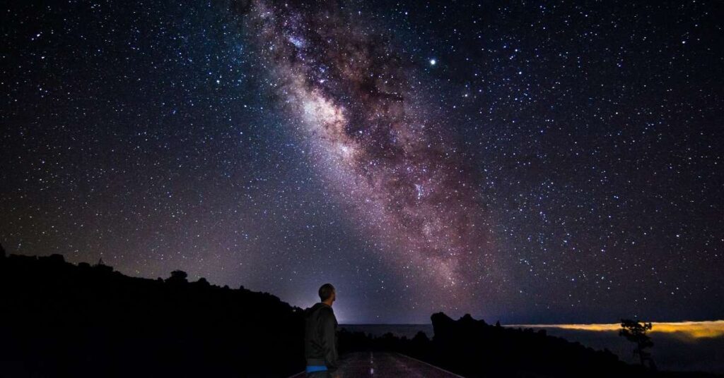 Human silhouette gazing into a vast, mysterious multiverse